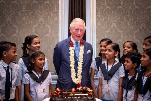 The Prince of Wales receives a birthday cake from school children during a British Asian Trust reception in Mumbai. Victoria Jones/PA Wire