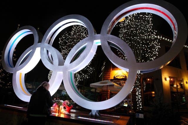 A makeshift memorial to Georgian athlete Nodar Kumaritashvili beside the Olympic Rings