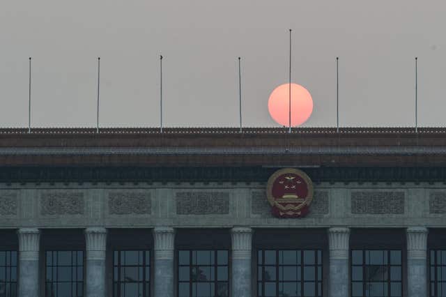 The sun sets over the Great Hall of the People on Tiananmen Square in Beijing (Stefan Rousseau/PA)