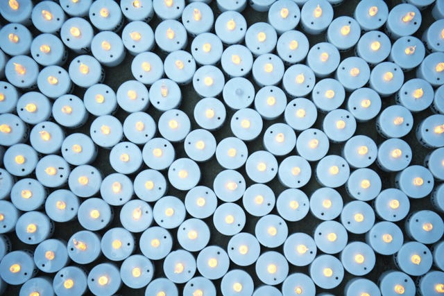 Lit candles bearing the names of health and social care workers that have died from coronavirus