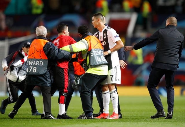 Cristiano Ronaldo tried to calm the situation after pitch invaders were tackled by steward (Martin Rickett/PA).