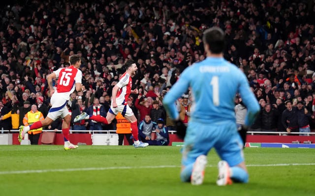 Real Madrid keeper Thibaut Courtois is left on his knees as Declan Rice celebrates scoring his second free-kick in Arsenal’s Champions League win in April