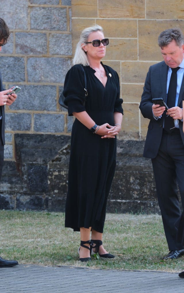 Harriet Bastide in black dress, standing outside