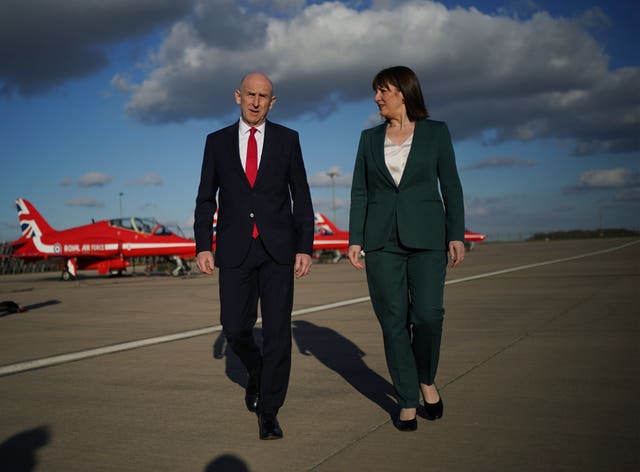 John Healey walking alongside Rachel Reeves on an airbase, with Red Arrow aircraft behind them