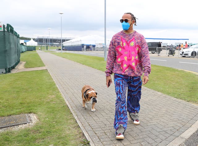 Lewis Hamilton and his dog Roscoe arrive at the paddock at Silverstone