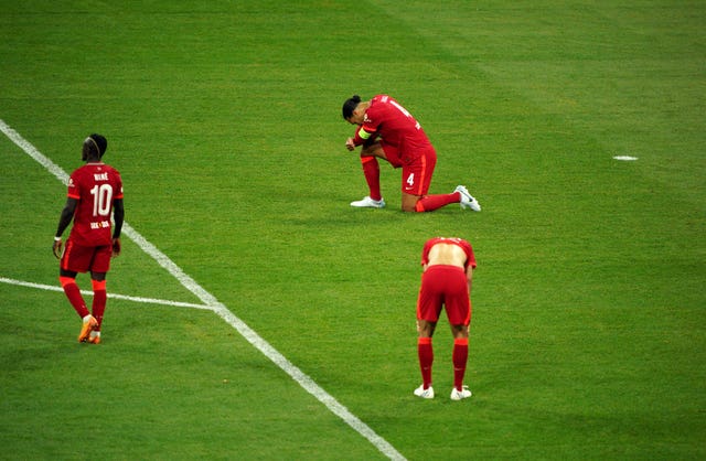 Liverpool defender Virgil Van Dijk kneels dejected on the pitch