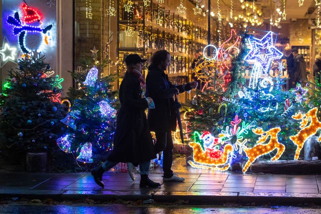 Shoppers pass a Christmas light display outside a store in Mayfair, in central London