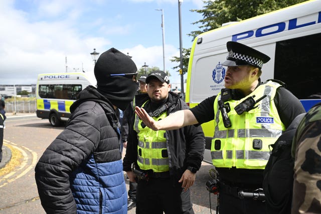 A police officer speaks to a protester during an anti-immigration protest in Glasgow
