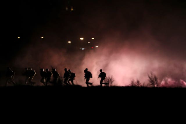 Soldiers running along the river bank