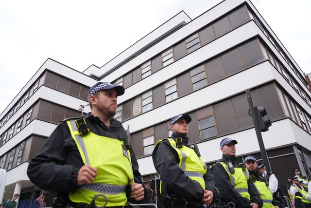 Police officers observe two groups of protesters outside a hotel in central London, which houses asylum seekers