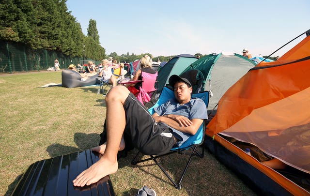 A spectator relaxes in the queue at the start of day five of Wimbledon 2018