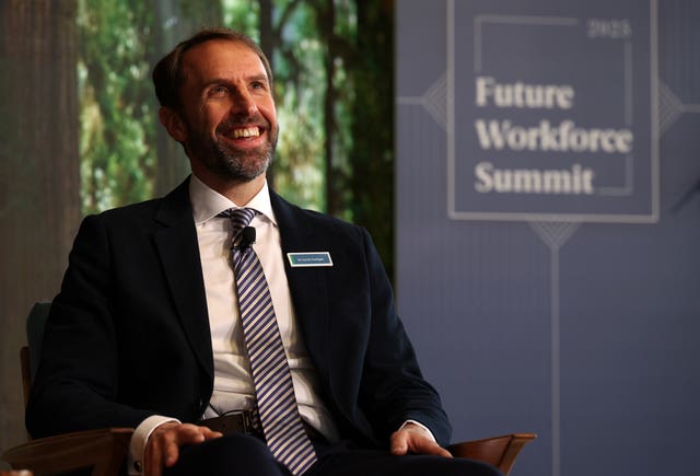 Sir Gareth Southgate sitting in a chair and laughing