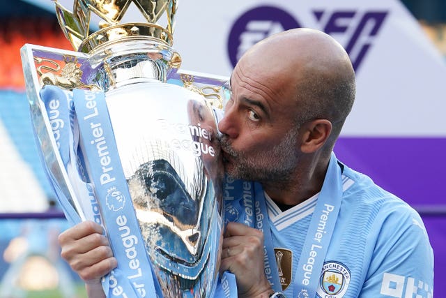 Pep Guardiola kisses the Premier League trophy