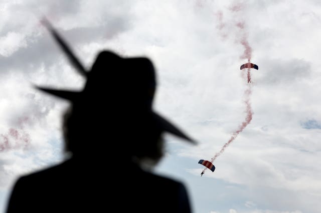 Camilla watches as the RAF Falcons Parachute Display Team drop onto the course