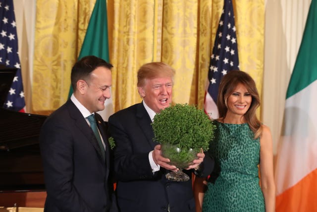 Leo Varadkar presents Donald Trump with a bowl of shamrock as Melania Trump looks on (Niall Carson/PA)
