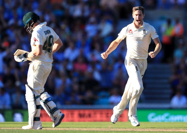 Chris Woakes, right, celebrates taking the wicket of Steve Smith