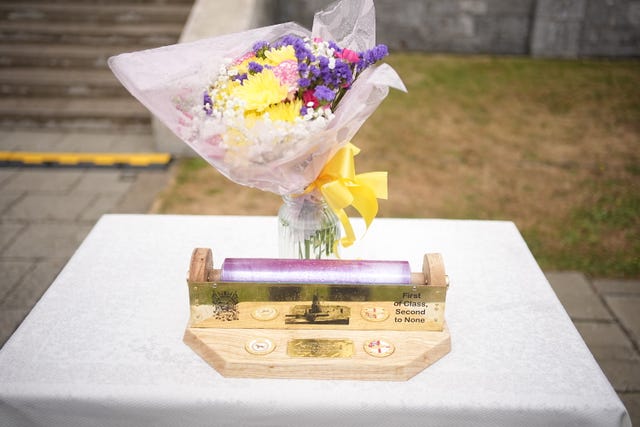 Flowers and a cling film roll holder that was presented to the Queen Camilla during a garden party for the HMS Astute Ship’s Company and their families