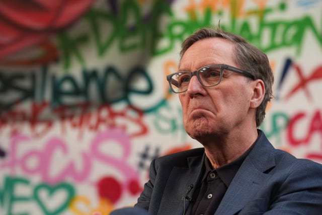 Alan Milburn standing in front of some graffiti artwork