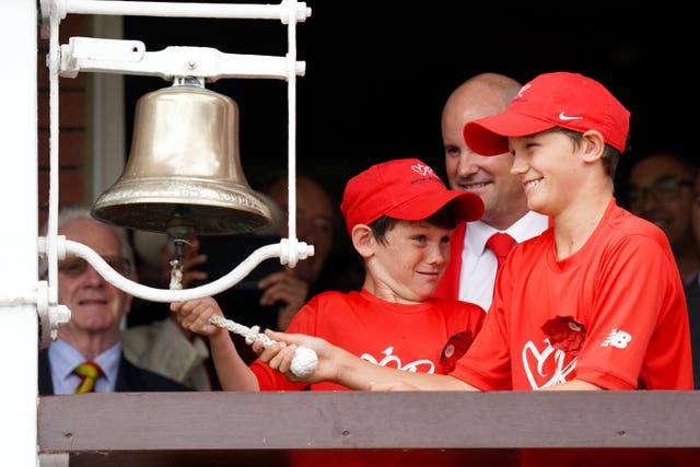 Andrew Strauss watches his sons ring the bell