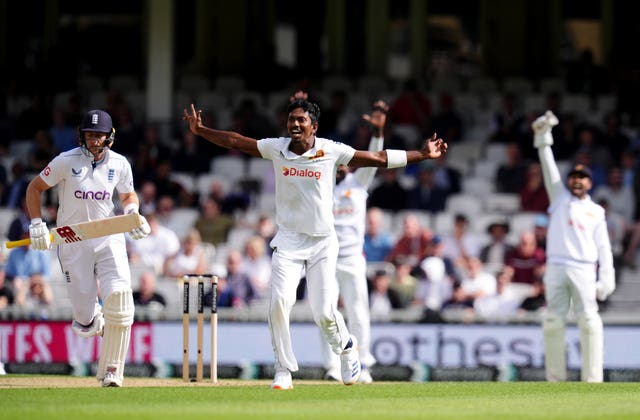 Vishwa Fernando, centre, successfully appeals to the wicket of Joe Root, left