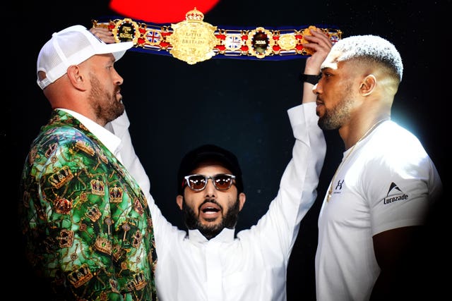 Tyson Fury (left) and Anthony Joshua face off as Turki Al-Sheikh holds aloft the Battle of Britain belt