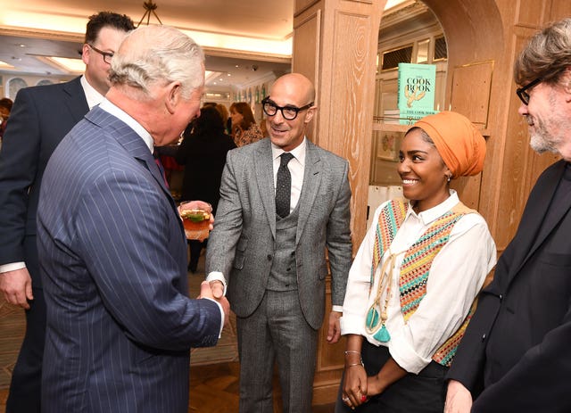 The Prince of Wales shakes hands with Stanley Tucci, watched by Nadiya Hussain
