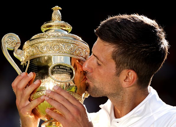 Sealed with a kiss: Novak Djokovic lifts the Wimbledon trophy for a seventh time