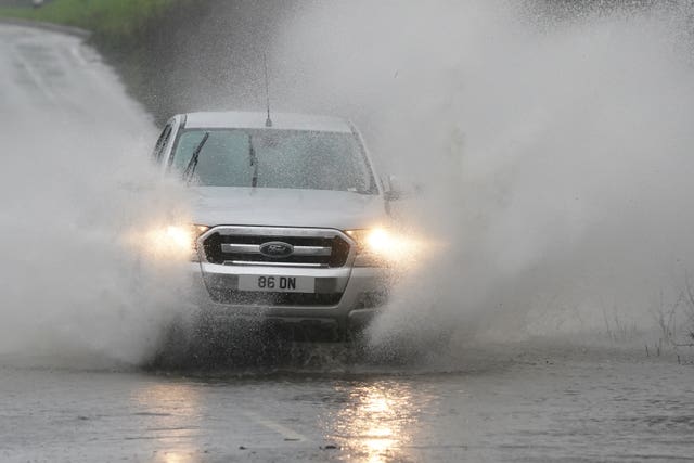 A vehicle driving through rain water on the A20 in Ashford, Kent