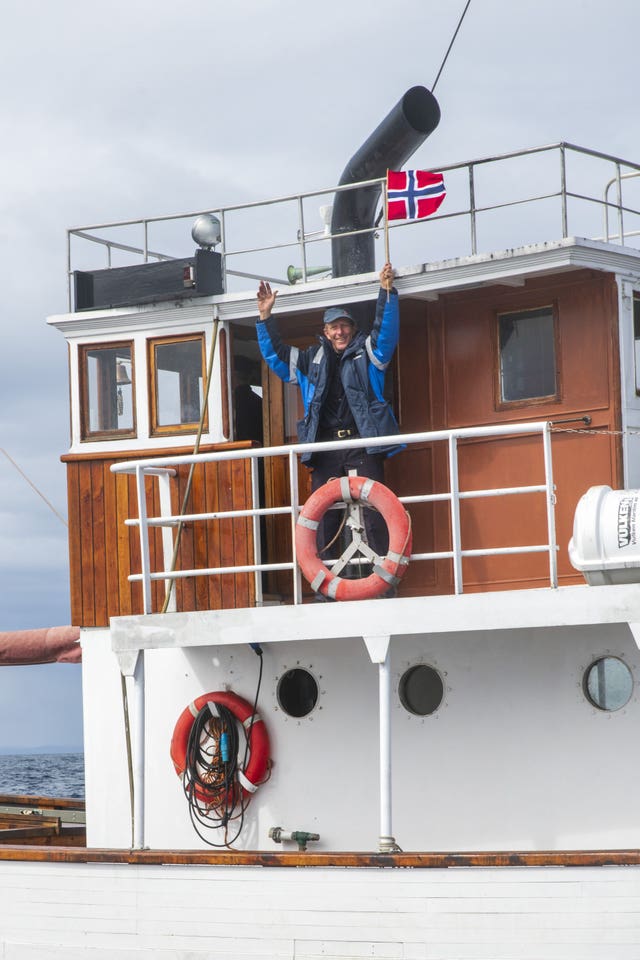 A person waves from a ship