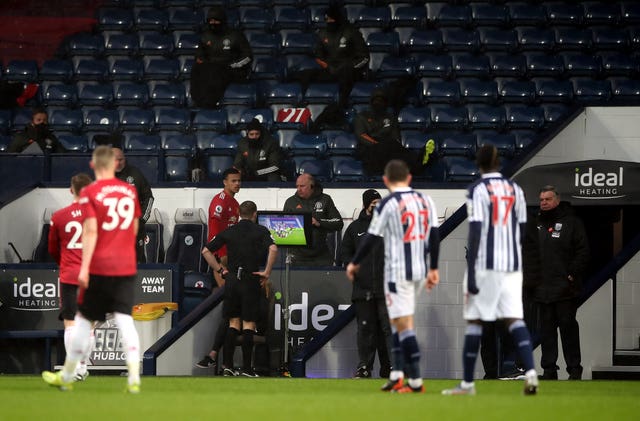 Referee Craig Pawson consults the pitchside VAR monitor 