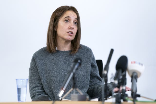 Louise Slorance speaking in front of a number of microphones