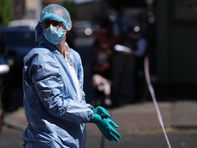 An officer in a forensic suit at the scene outside Lopez House on Willington Road in Clapham, south London