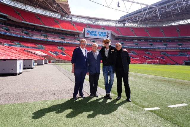 Executive producer John Kennedy, concert promotor Harvey Goldsmith, Bob Geldof and Midge Ure on the pitch during the launch event for the Live Aid musical Just For One Day, at Wembley Stadium