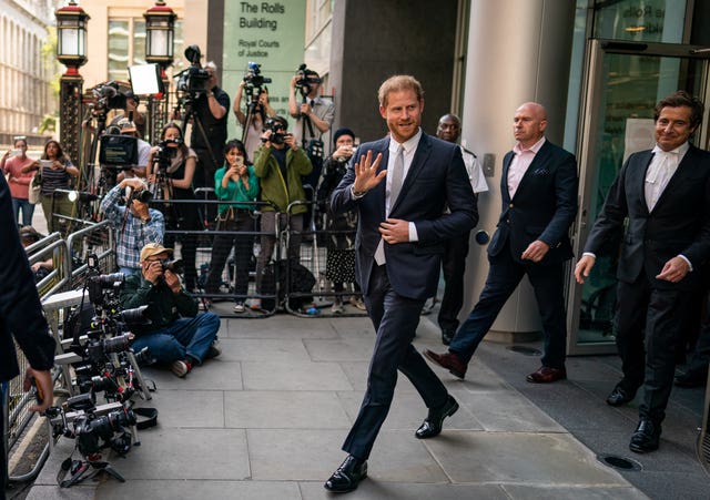 Harry waves as he leaves the Rolls Buildings in London