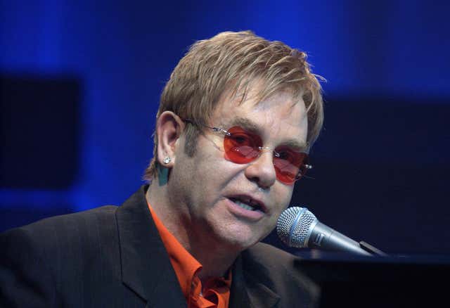 Sir Elton John at a microphone