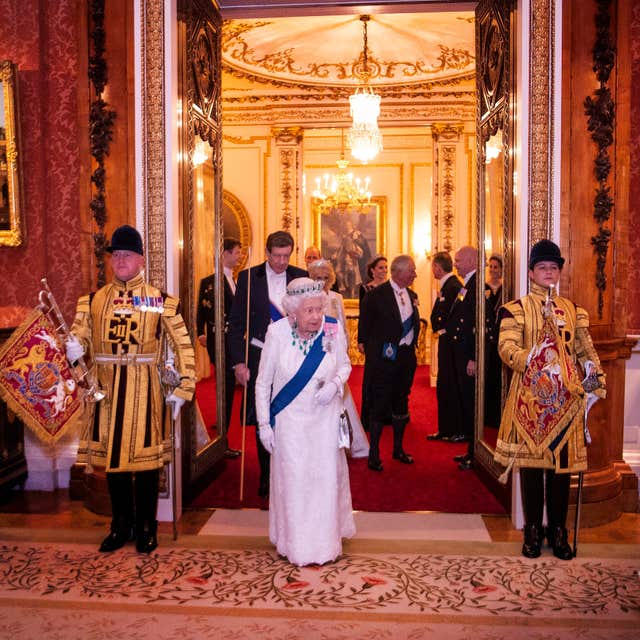 Queen Elizabeth II entering the room years later at the annual evening reception for Members of the Diplomatic Corps at Buckingham Palace in 2019