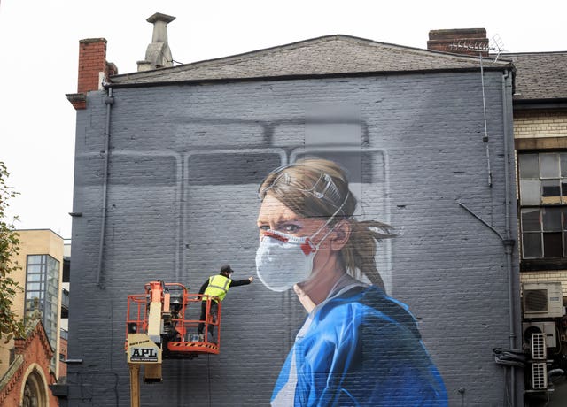 Artist Peter Barber works on a mural in Manchester city centre of Johannah Churchill 's photograph. Danny Lawson/PA Wire