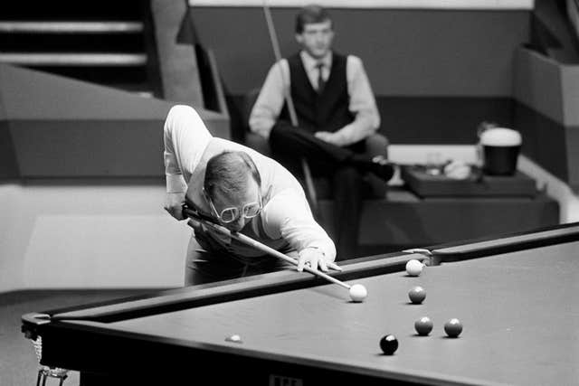 Dennis Taylor seen in action during the 1985 Embassy World Snooker Championships, held at The Crucible Theatre in Sheffield. His opponent, Steve Davis, can be seen in the background.