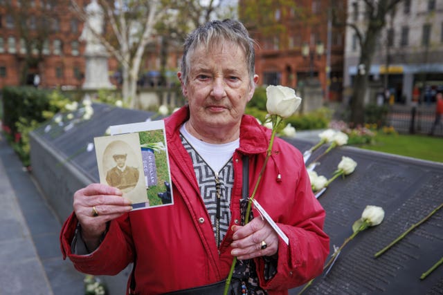 Marjorie Wilson holding an image of her grandfather William McQuillan