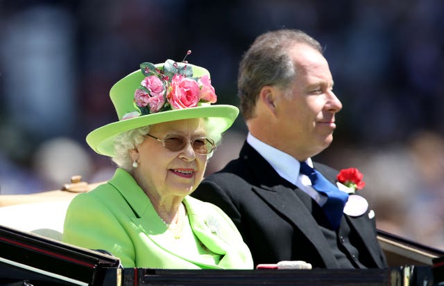The Queen and a guest arrive at Royal Ascot in the traditional carriage procession. (John Walton/PA)