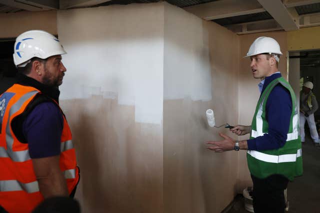 The Duke of Cambridge gets down to some wall-painting, in the company of Nick Knowles (Adrian Dennis/PA)