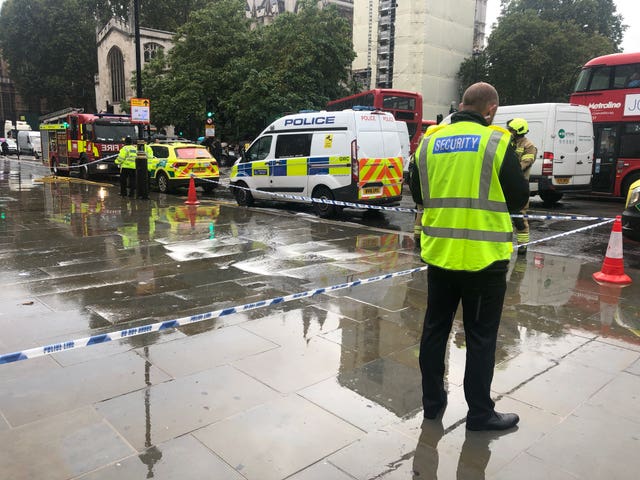 Police at the scene near the Houses of Parliament after a man was detained by police after pouring a flammable liquid over himself