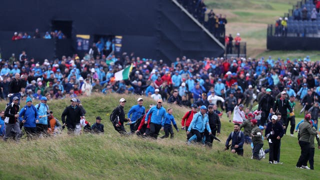 Fans rush on to the course