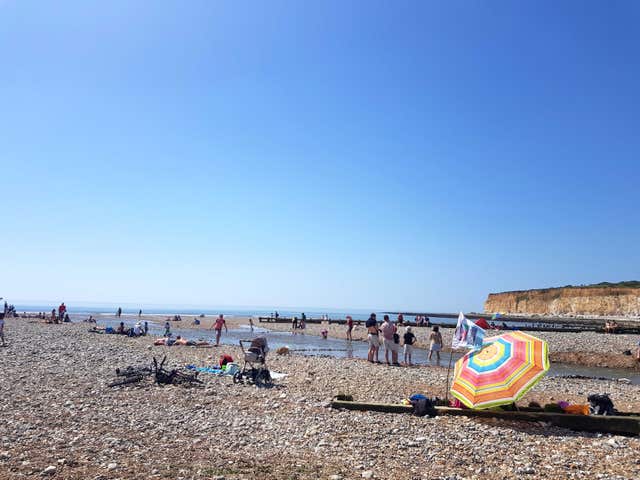 The beach beside the Seven Sisters Cliffs in Sussex was popular with sun-seekers (Catherine Wylie/PA)