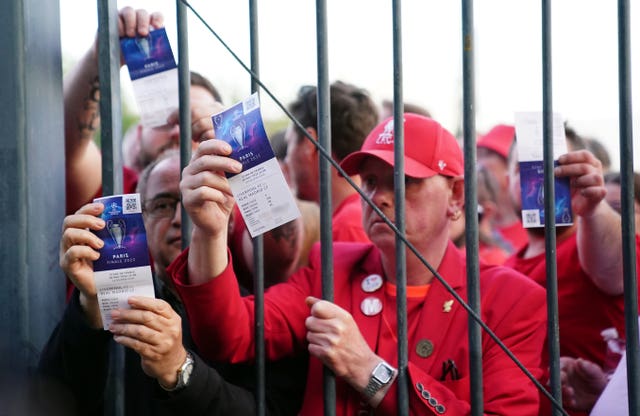 Liverpool fans stuck outside the ground show their match tickets