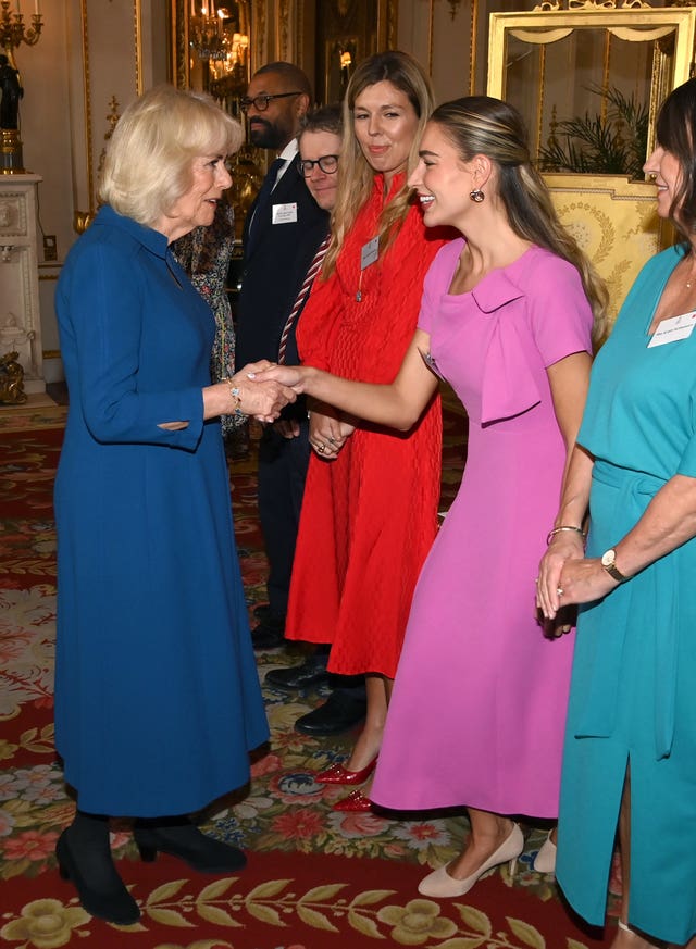 Camilla shakes hands with Zara McDermott at the reception