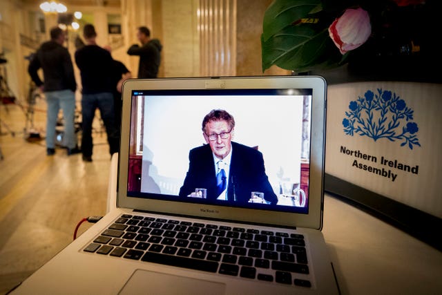 A laptop shows Sir Patrick delivering his findings from his Renewable Heat Incentive public inquiry in the Long Gallery at Stormont, Belfast