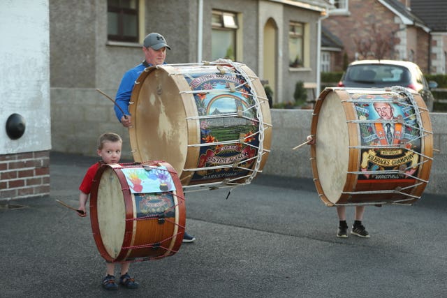 Mark Black and his sons, Thomas, left, four, and Adam, 10, from Markethill in Co Armagh, Northern Ireland, play Lambeg drums outside their home to salute local heroes during Thursday’s nationwide Clap for Carers initiative