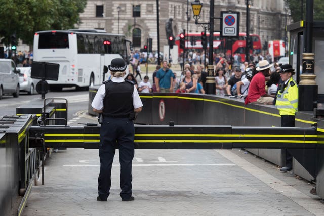 Police officers by the barrier outside the Houses of Parliament 