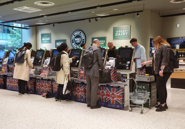 People using self-service checkouts at an M&S store in London